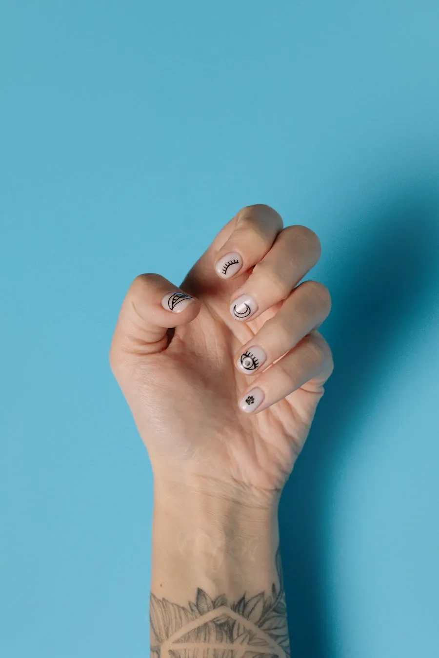 Soft blush nude nails on a pale background