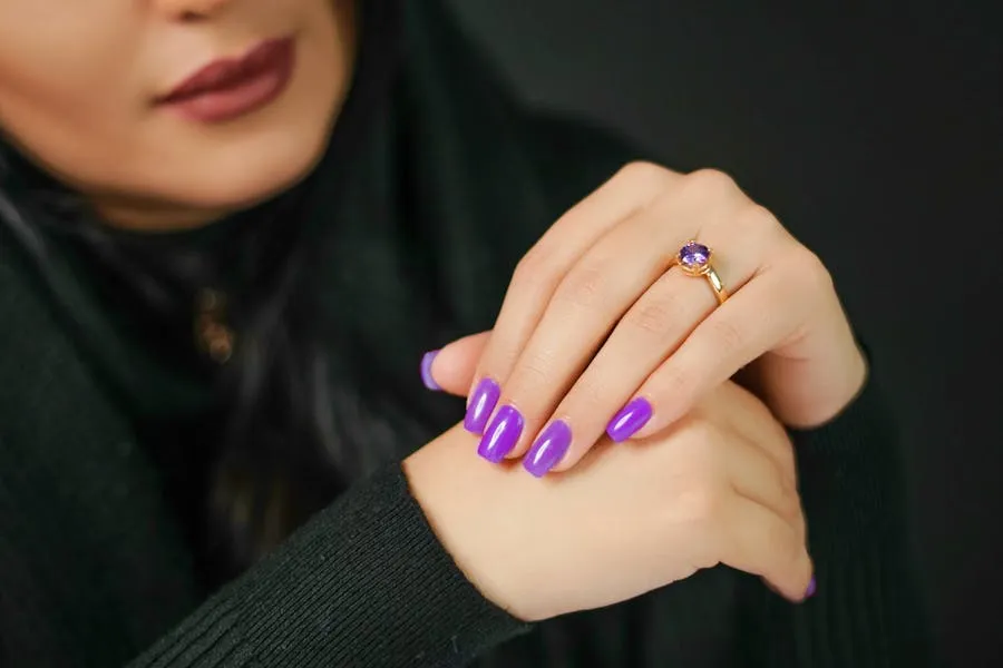 Deep violet amethyst nails against a black sweater